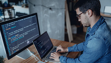 A male programmer works on the laptop.