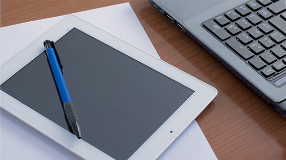 Tablet with a pen and partial laptop keyboard 