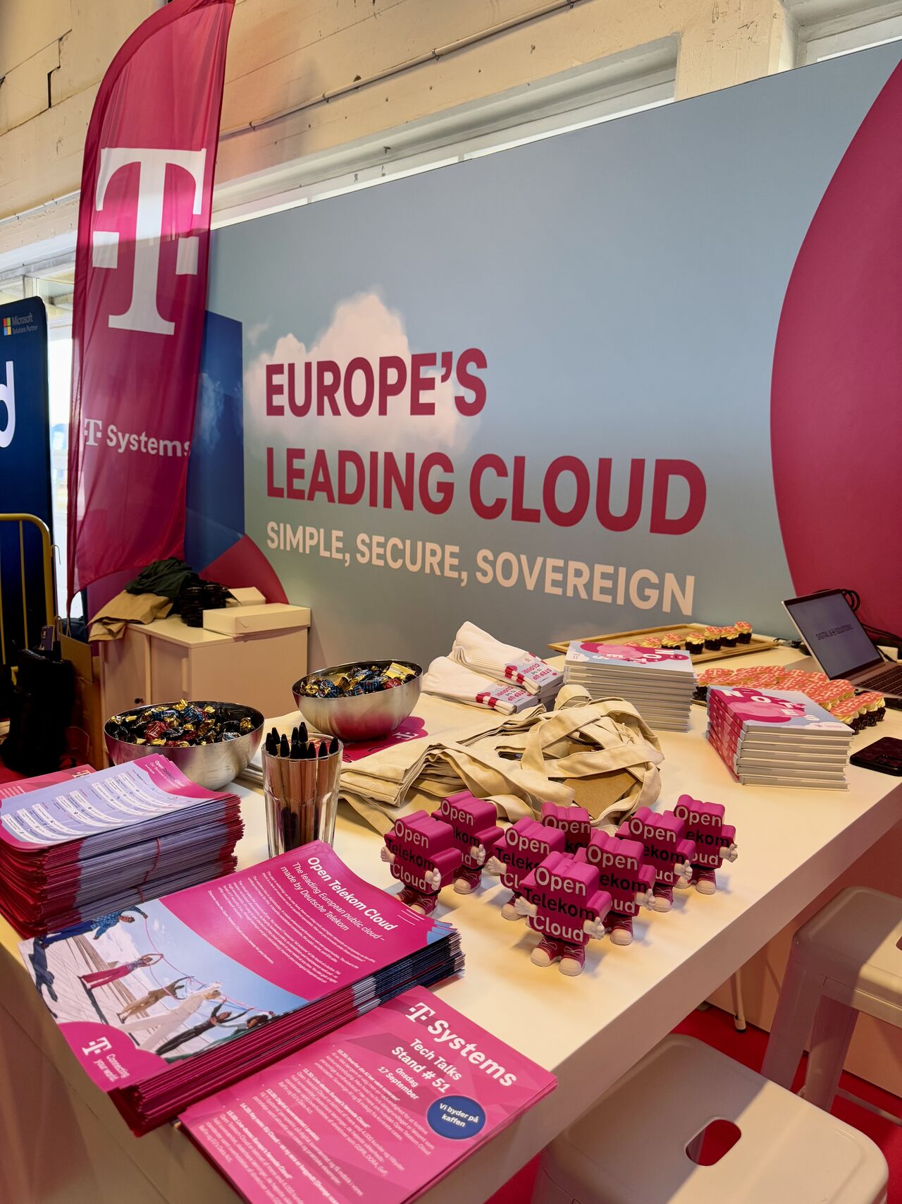 T-Systems Messestand mit Flyern, Giveaways und Banner zur Open Telekom Cloud