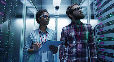 A man and a woman inspecting a server room