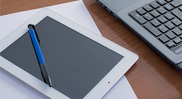 Tablet with a pen and partial laptop keyboard