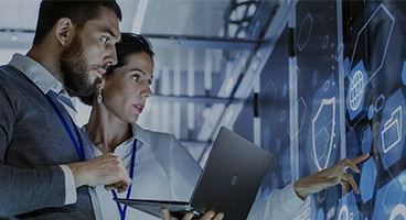 A woman and a man with laptop in a data center 