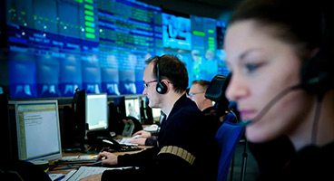 People in front of screens in the data center