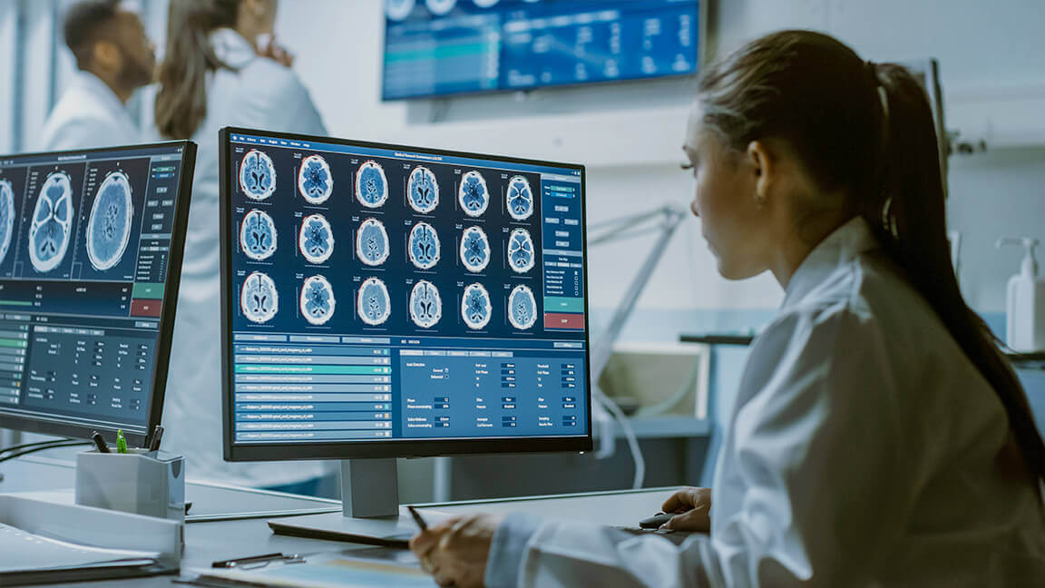 Woman in doctor coat in front of screen