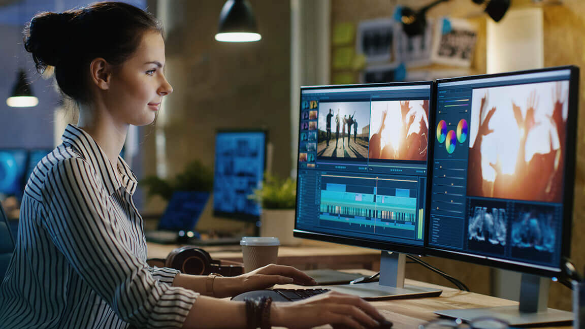 A woman working using two monitors