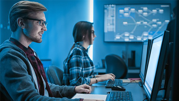 Two employees work on the PC.
