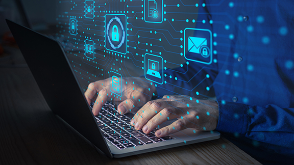 Male hands typing on a laptop with a hologram in the foreground displaying many apps.