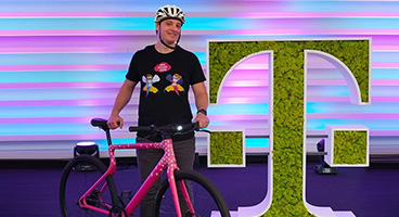 German Santini with bicycle next to planted horizontal T of Telekom