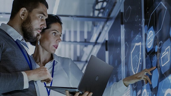 A woman and a man with laptop in a data center 