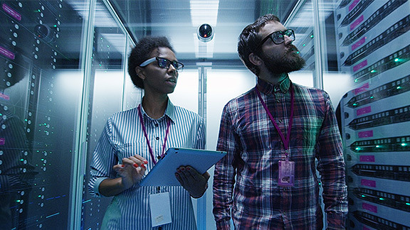 A man and a woman inspecting a server room