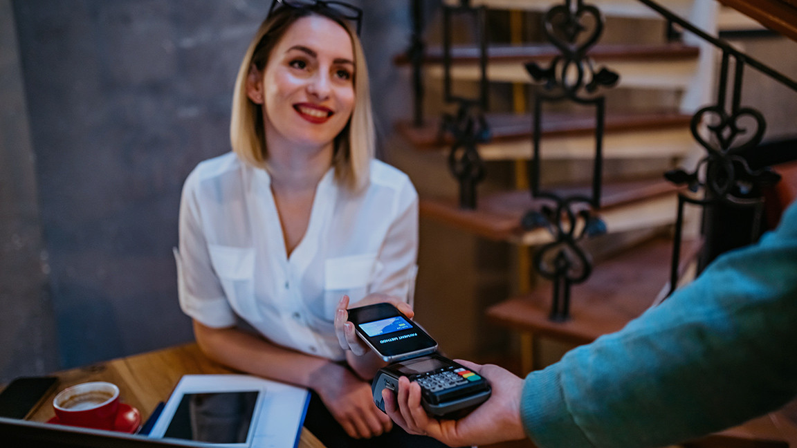 Woman pays with smartphone on card reader