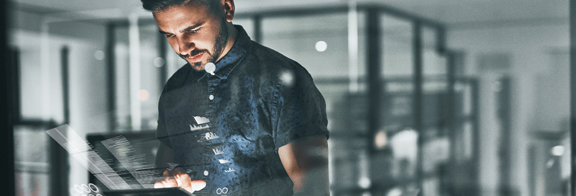 A man works in an office using a tablet.