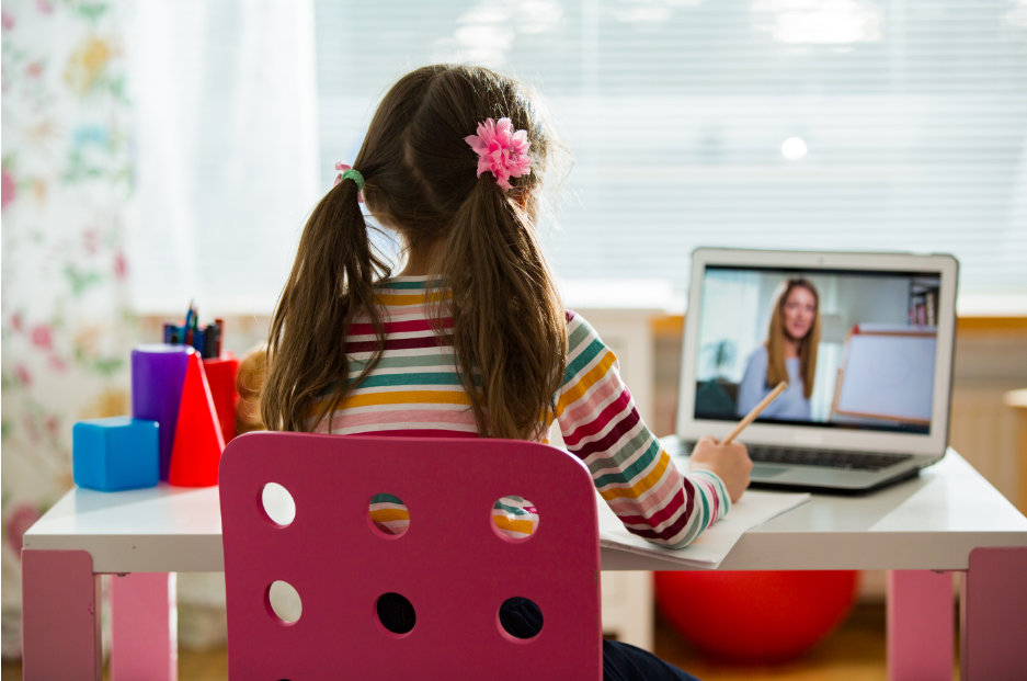 A girl in front of the laptop taking part in an online class.  