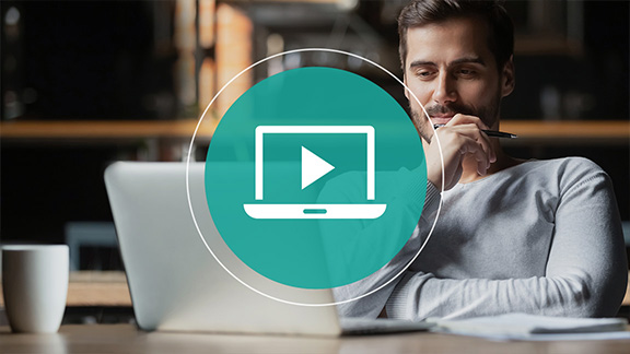 A man sits in front of a laptop