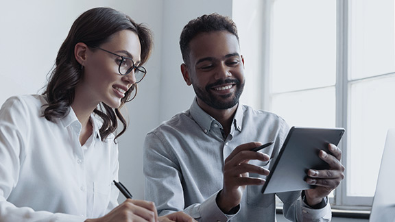 A woman and a man look at a tablet