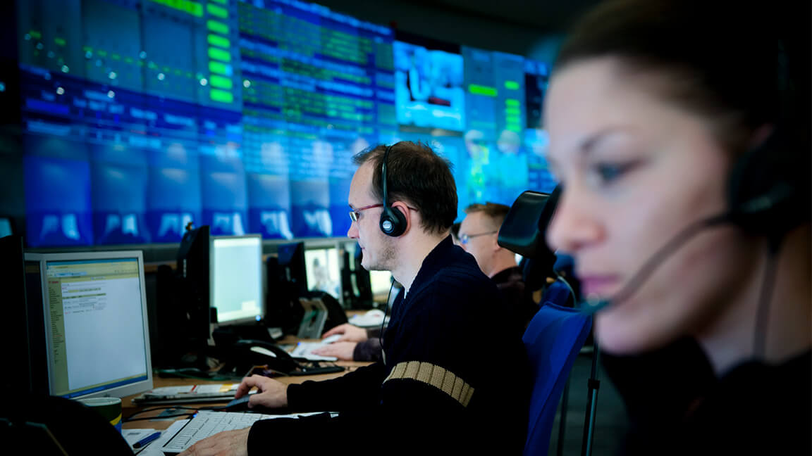 People in front of screens in the data center