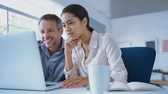 Zwei Personen arbeiten gemeinsam an einem Laptop